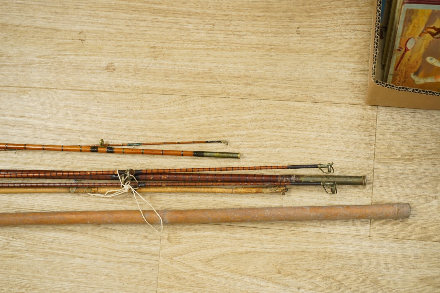 A collection of split cane fishing rods, reels, landing net etc contained in a large wooden box
